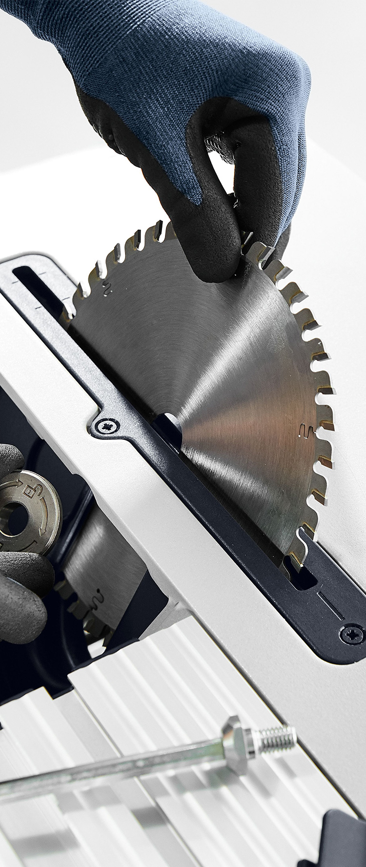 Worker securing a circular saw blade to a table saw