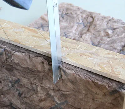 Positioning templates and cutting into insulation between rafters