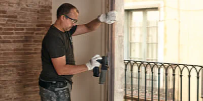 A painter sands the window frames with the Festool cordless sander